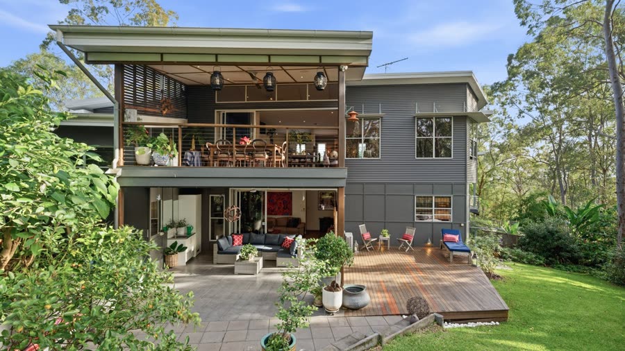 Dusk exterior of a two-storey contemporary home with an upper-level deck