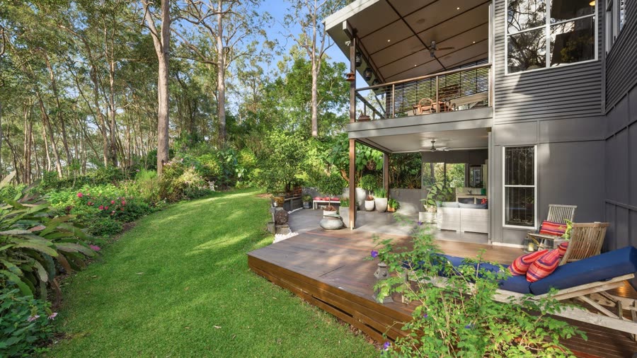 A landscaped garden leading to a covered outdoor lounge deck
