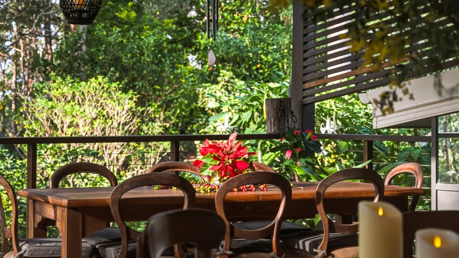 An outdoor dining table set with a floral centrepiece and candles